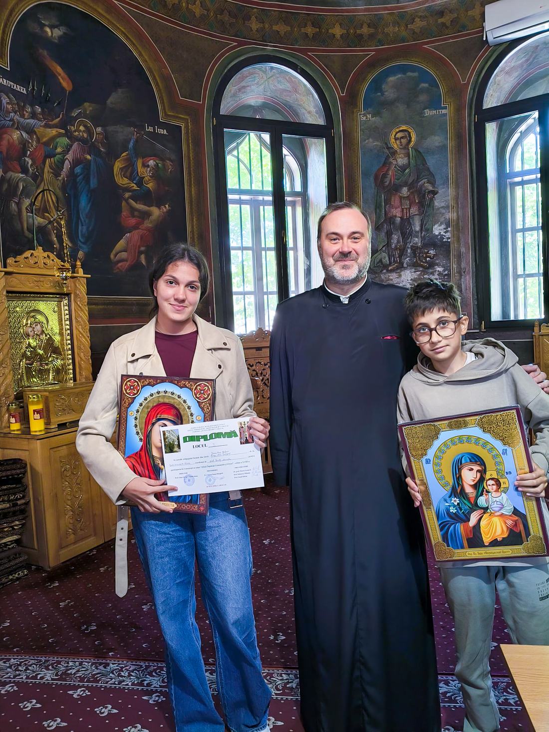Preoți vorbind elevilor despre hramul bisericii