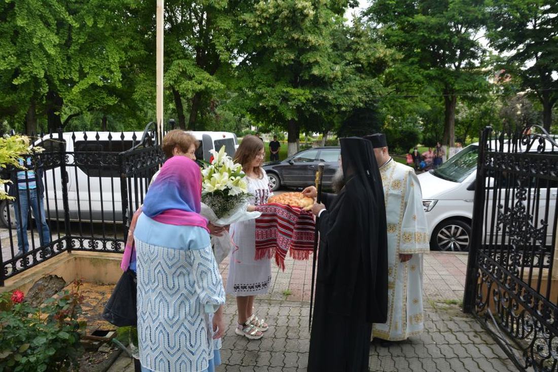 Episcopul Sebastian primind pâine și flori din partea comunității