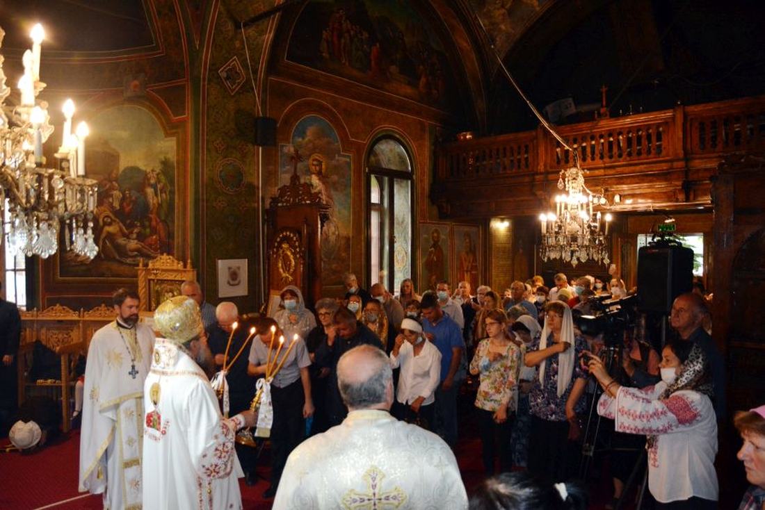 Procesiune liturgică în interiorul bisericii, cu credincioși de față