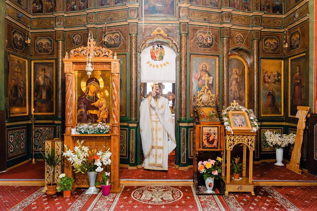 Preotul paroh binecuvântând în altar