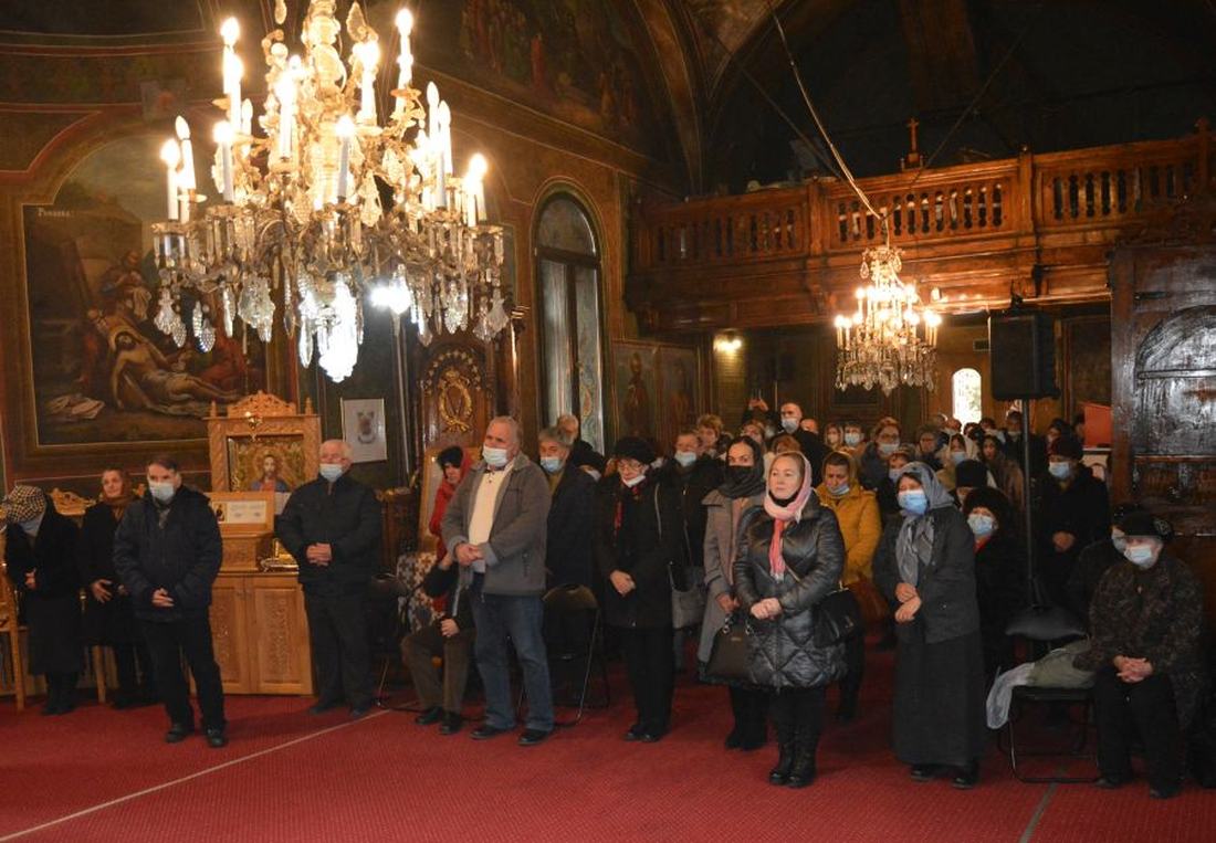 Credincioși participând la slujbă în biserică